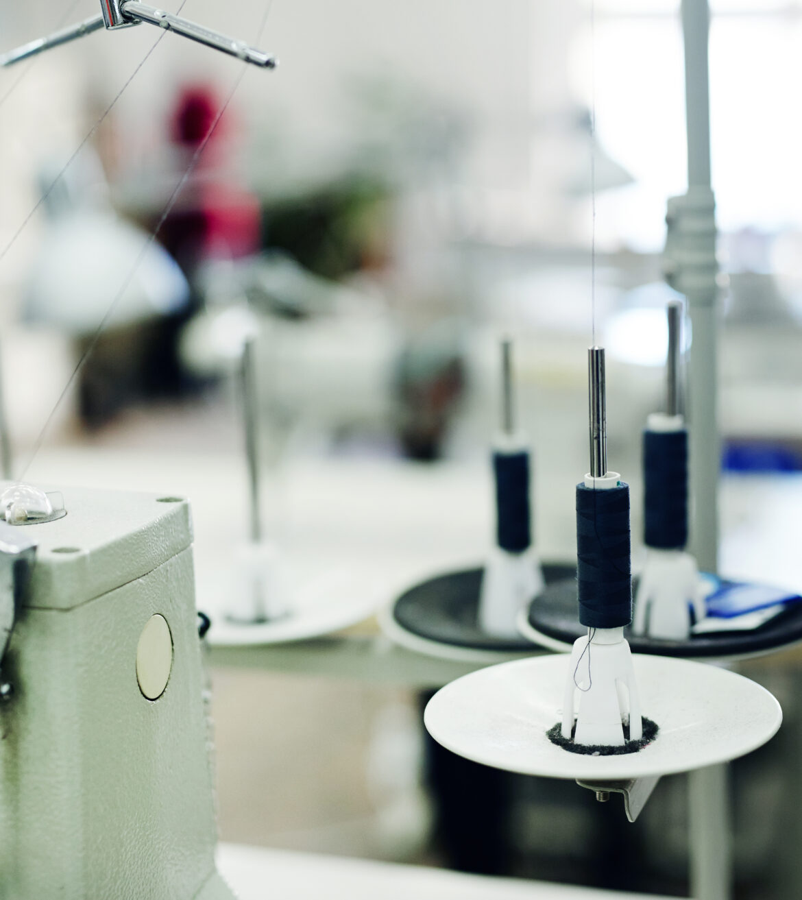 Thread spool ready for usage and part of sewing machine in tailor workshop